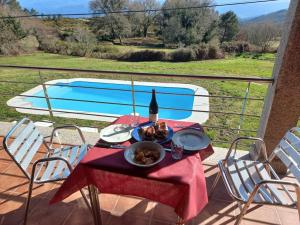 un tavolo con una bottiglia di vino e cibo sul balcone di Lobetios - Casa rural a Parada de Achas