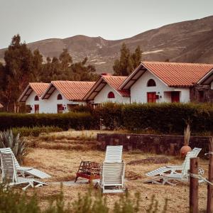 a group of chairs sitting in front of a house at Casona Plaza Ecolodge Colca in Yanque