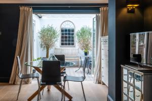 ein Esszimmer mit einem Tisch, Stühlen und einem Fenster in der Unterkunft The Brunswick Oasis in London
