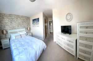 a bedroom with a bed and a tv and dresser at Luxury 8th Floor Apartment with Stunning Views in Chatham