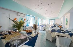 una grande sala banchetti con tavoli con sopra cibo di Hotel Stella Maris Terme a Ischia