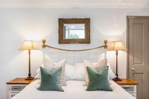 a bedroom with a white bed with two lamps at The Brunswick Oasis in London