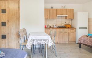 een keuken met een tafel en stoelen en een koelkast bij Amazing Apartment In Dominikowo With Kitchen in Dominikowo