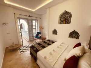 sypialnia z łóżkiem i krzesłem w pokoju w obiekcie Riad 212 Marrakech Medina w Marakeszu