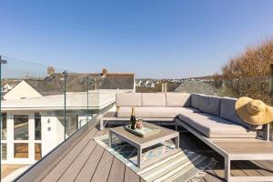 a patio with a couch and a table on a roof at Luxury Family Beachside Home inc Hot Tub & Parking in Broad Haven