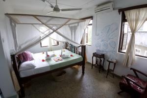 sypialnia z łóżkiem w pokoju z oknami w obiekcie Zenji Hotel w mieście Zanzibar