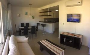 een woonkamer met een bank en een eetkamer bij Green Park Hermosos Apartamentos Vista al Lago in Punta del Este