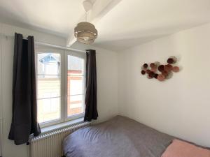 een slaapkamer met een bed en een raam bij Cristal House in Trouville-sur-Mer