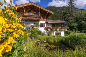 een huis met een tuin en bloemen ervoor bij Martinsklause in Maishofen