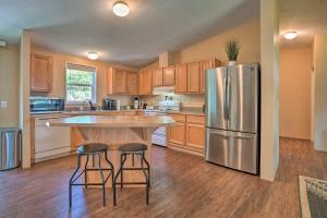 a kitchen with a stainless steel refrigerator and two bar stools at Lovely Detroit Home with Deck - Walk to Town! in Detroit