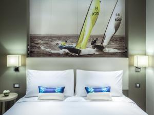 
a hotel room with a large bed and a painting on the wall at Mercure Pattaya Ocean Resort - SHA Extra Plus in Pattaya
