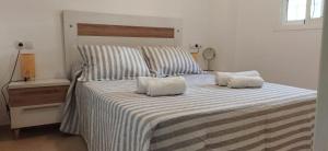 a large bed with two pillows on top of it at Apartamentos Costa de la Luz playa in Rota