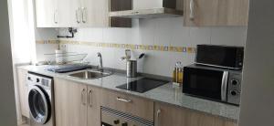 a kitchen with a sink and a microwave at Apartamentos Costa de la Luz playa in Rota