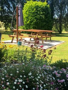 a wooden picnic table in a park with flowers at lagalerne in Neuville-de-Poitou