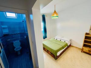 1 dormitorio con cama, ducha y aseo en Cozy Surf House, en Taghazout