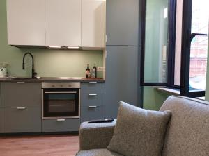 uma cozinha com 2 cadeiras e um fogão forno superior em 2 Via Fabio Mangone em Milão