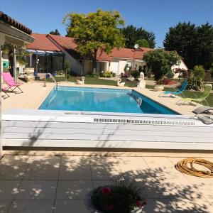 Neuville-du-Poitou的住宿－lagalerne，一座带房子的庭院内的游泳池