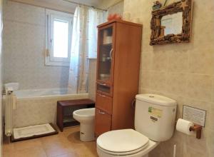 łazienka z toaletą, umywalką i wanną w obiekcie Apartamento EntreRíos w mieście Barbastro