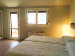 sypialnia z łóżkiem i 2 oknami w obiekcie Apartamento EntreRíos w mieście Barbastro