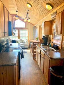 a kitchen with wooden cabinets and a living room at The Armadillo Cabin - Cabins At Rim Rock in Austin