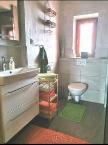 a bathroom with a sink and a toilet and a window at Ferienwohnung Haus Germania in Brixen im Thale