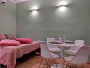 Habitación con cama, mesa y sillas. en 2 Via Fabio Mangone, en Milán