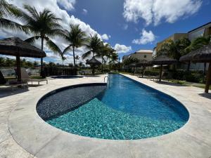 a swimming pool with blue water and palm trees at APT 2/4 LUXO IBEROSTATE in Praia do Forte