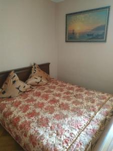 a bedroom with a bed and a picture on the wall at Просторная квартира с большим залом и спальней in Vinnytsya