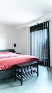 a bedroom with a red bed and a window at B&B Koor91 in Hasselt