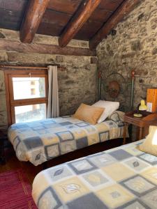 a bedroom with two beds and a window at Apartaments Casa Vella Popaire in Soldeu