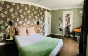 ein Schlafzimmer mit einem Bett und einer floralen Wand in der Unterkunft Hôtel du Roy in Aisey-sur-Seine