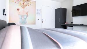 a bedroom with a bed and a painting of a man on the wall at B&B Koor91 in Hasselt