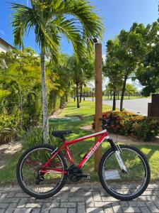 a red bike is parked next to a pole at APT 2/4 LUXO IBEROSTATE in Praia do Forte