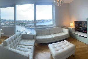 ein Wohnzimmer mit zwei weißen Sofas und einem großen Fenster in der Unterkunft Luxury 8th Floor Apartment with Stunning Views in Chatham