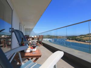 a balcony with chairs and a table with a view of the water at 2 Poundstone Court in Salcombe