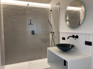 a bathroom with a glass shower with a black sink at Ferienwohnung Schauplats in Innsbruck