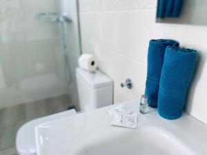 Baño con lavabo blanco y toallas azules. en Villa Julia Relax Dream Holiday en Callao Salvaje