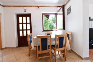 ein Esszimmer mit einem Tisch, Stühlen und einem Fenster in der Unterkunft Holiday Home Matan in Saborsko