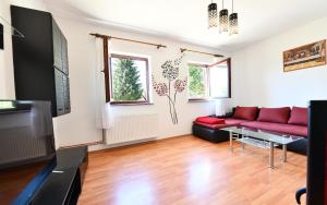 a living room with a red couch and a tv at Holiday Home Matan in Saborsko