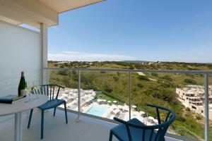 a room with a view of the pool and the ocean at Palladium Hotel Menorca in Arenal d'en Castell