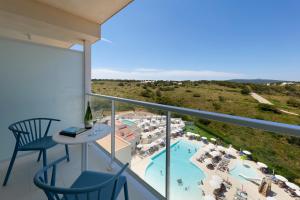 a balcony with a view of a resort with a pool at Palladium Hotel Menorca in Arenal d'en Castell
