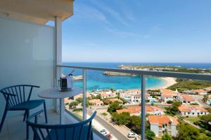 a balcony with two chairs and a view of the ocean at Palladium Hotel Menorca in Arenal d'en Castell