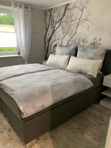 1 dormitorio con 1 cama grande con almohadas blancas en Ferienwohnung Rotbuche en Tannenberg