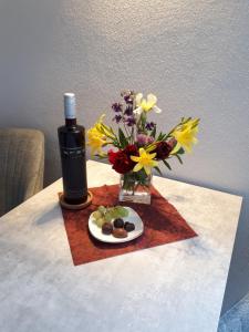 - une table avec une bouteille de vin et un vase de fleurs dans l'établissement Ferienwohnung Rotbuche, à Tannenberg