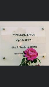 una señal para un jardín con una rosa rosa en Chambre d'Hôte Touquet's Garden, en Cucq