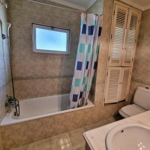 a bathroom with a tub and a sink at Tavira City Center 3Br in Tavira