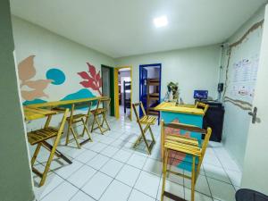 una habitación con mesas, sillas y un mostrador en Aloha Hostel Pinhões, en Fortaleza