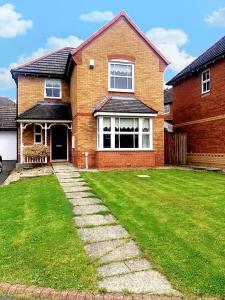 a brick house with a green lawn in front of it at Spacious 4 bed home in a quiet cul-de-sac in Coundon