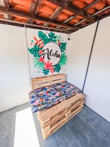 a room with a wall with a sign on it at Aloha Hostel Pinhões in Fortaleza