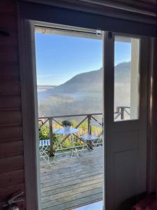 eine Tür, die auf eine Terrasse mit einem Tisch und Stühlen führt in der Unterkunft Ateljéstugan med magisk utsikt in Nordingrå